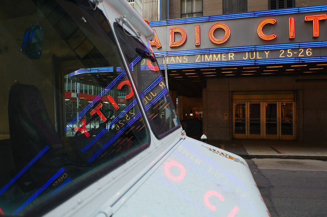 Outside broadcast truck parked in a city street at dusk